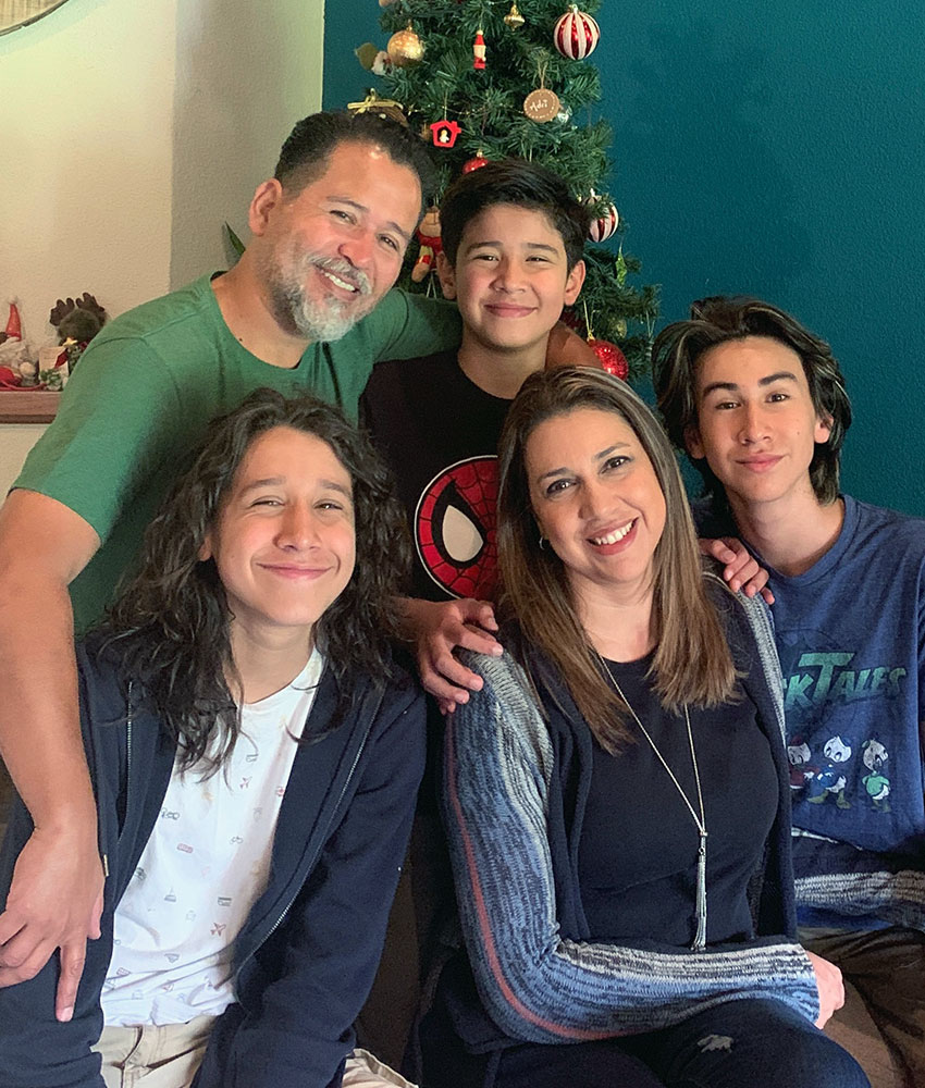 Montenegro family in front of christmas tree smiling