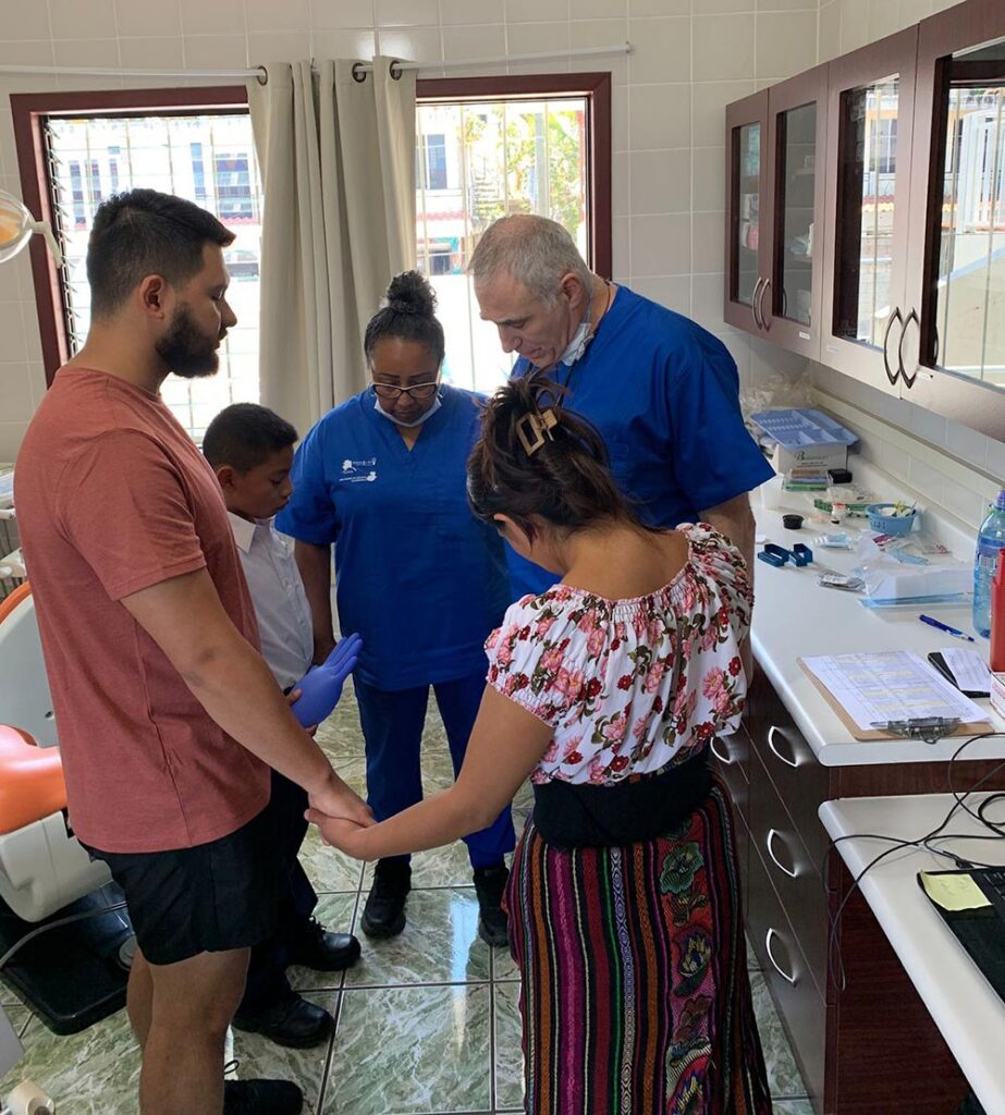 dental team prays with family